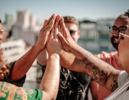 A group of people high-fiving each other outdoors.